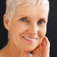 Smiling woman with one hand to face